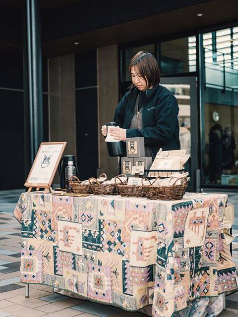 柄布をかけた机で準備をする店主