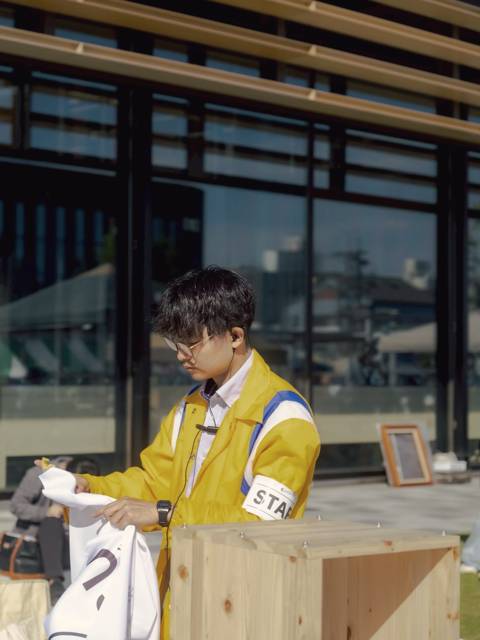 木の箱を前に品物を広げる店主